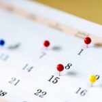 Closeup Colorful drawing pins on Calendar page with date